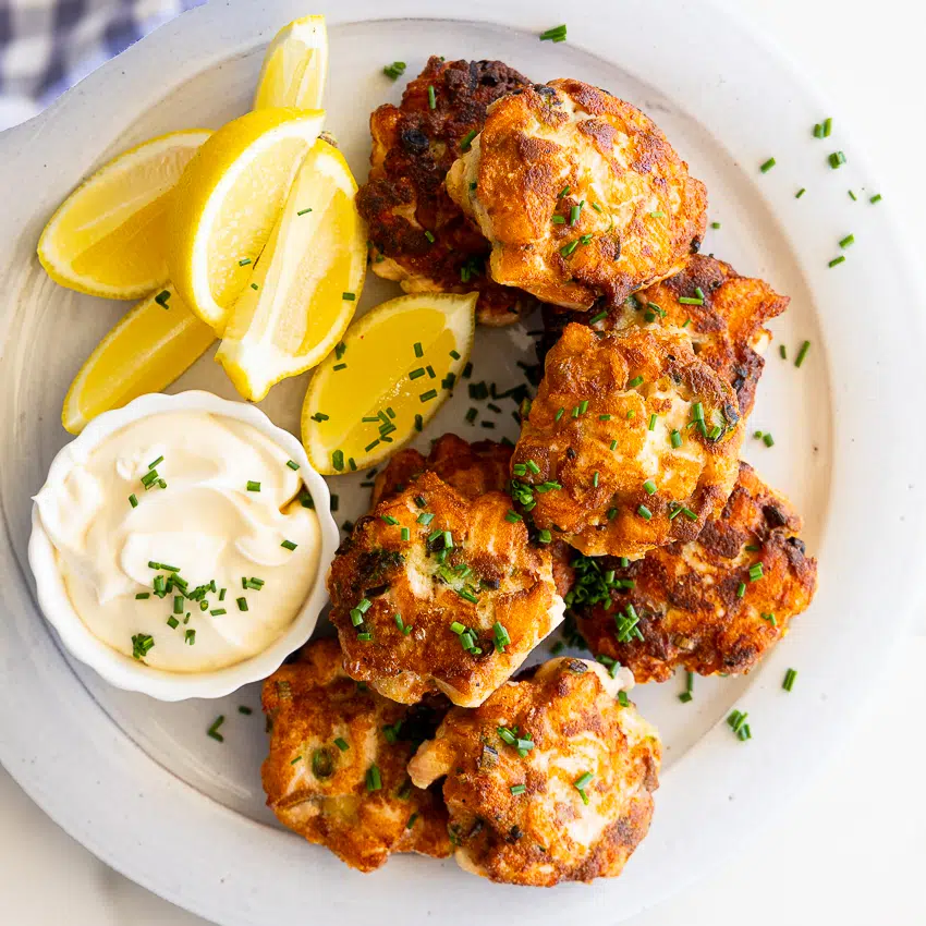 Salmon cakes with dipping sauce and lemon wedges