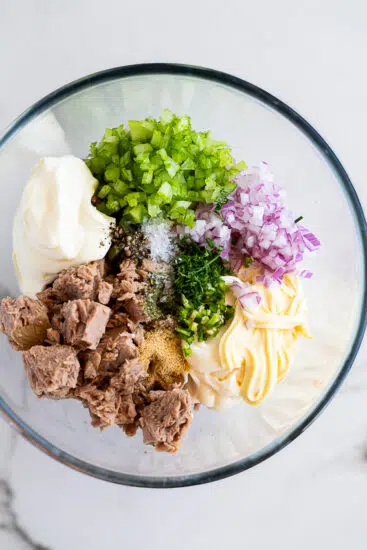 Ingredients for tuna salad in a mixing bowl.
