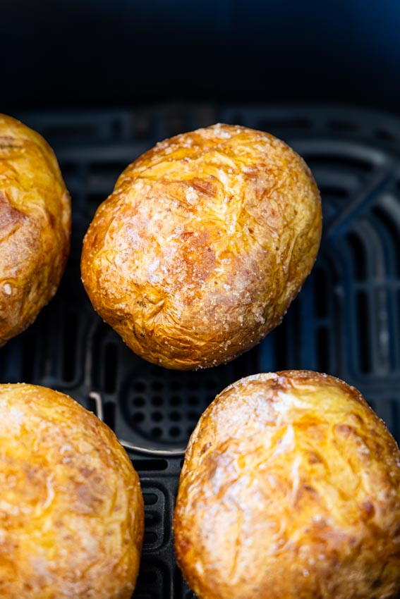 Baked potato in air fryer basket.