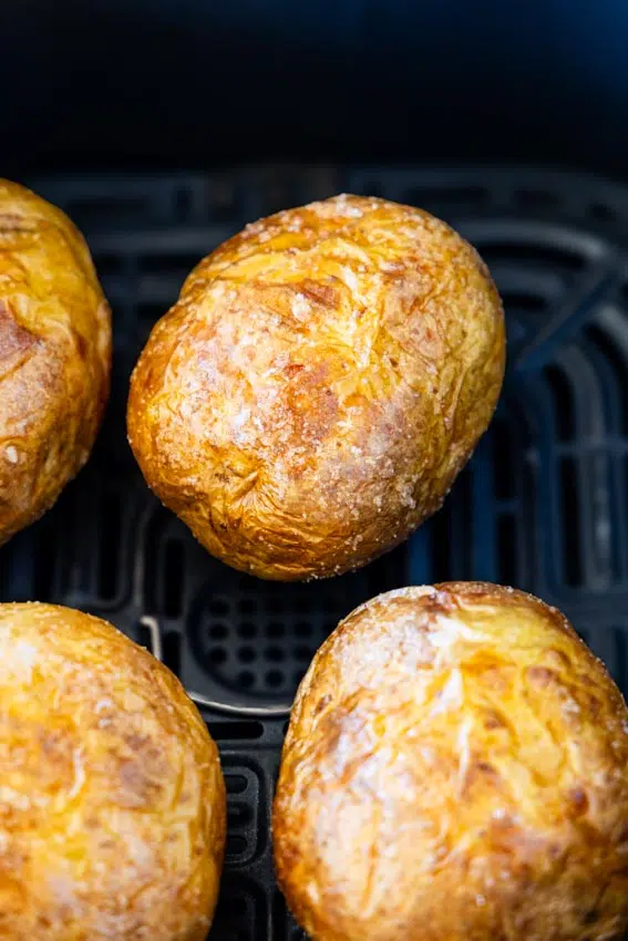 Baked potato in air fryer basket.