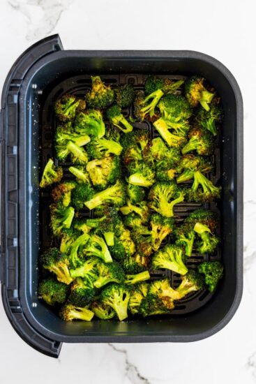 Cooked broccoli in air fryer basket