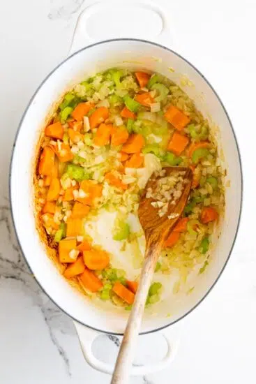 Fried carrots, onions and celery in pot.