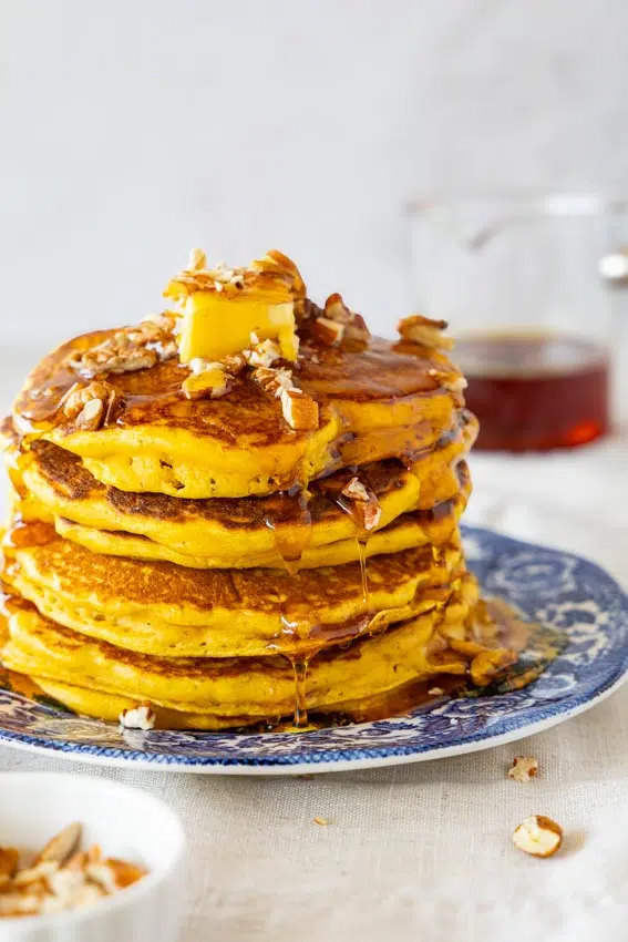 Pumpkin pancakes with butter, maple syrup and pecans.