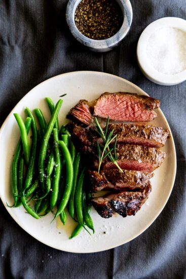 Air fryer steak with green beans on a plate.