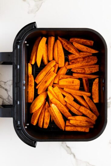 Sweet potato wedges in air fryer basket.