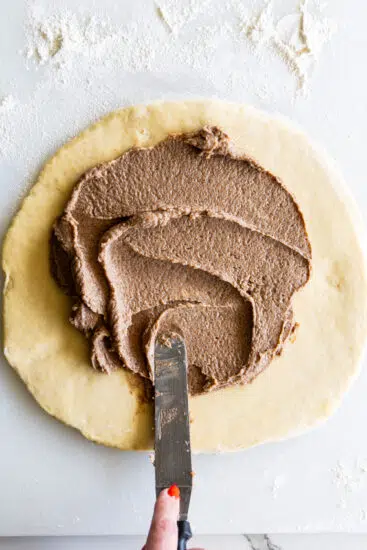 Cinnamon butter spread over dough.