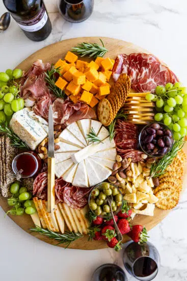 Cheese board with crackers, fruit and charcuterie.