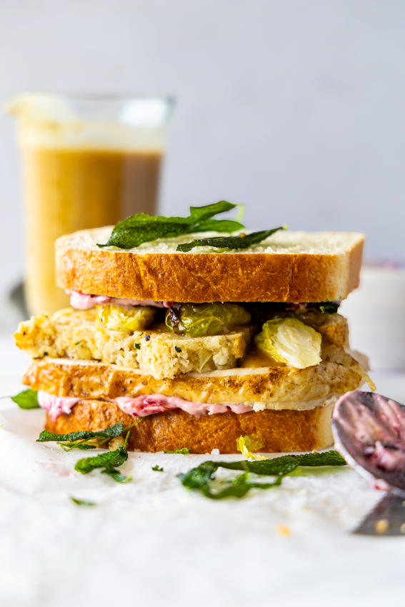 Thanksgiving Leftover Sandwich with turkey, stuffing, brussels sprouts and cranberry mayo drenched in gravy.