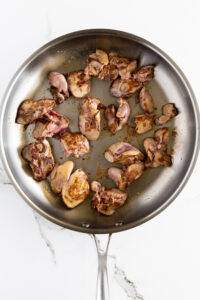 Chicken livers seared in hot pan.