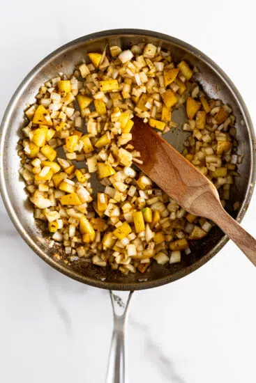 Onions, apples and garlic sautéed in pan.