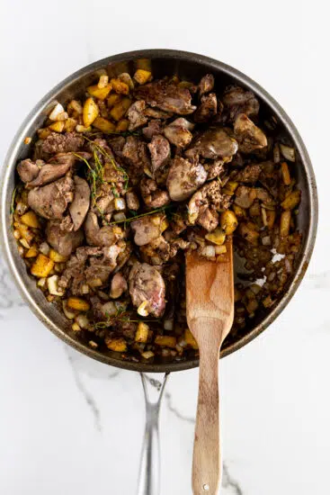 Chicken livers in pan with onions and apples.