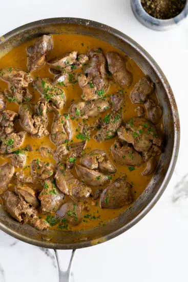 Chicken livers in creamy sauce garnished with chopped parsley.
