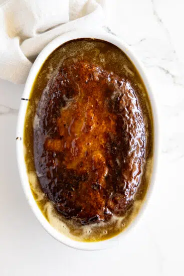 Baked Malva pudding in a white baking dish.