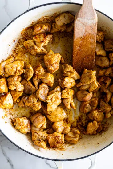 Seasoned chicken seared in a pan.