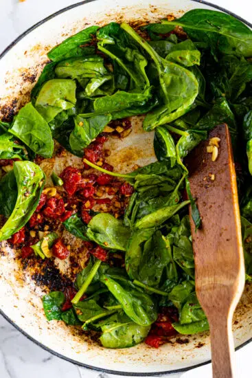 Sun-dried tomatoes and spinach added to pan.
