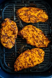 Air fried chicken breast in air fryer basket.