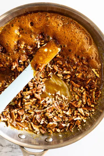 Chopped pecans stirred into caramel.
