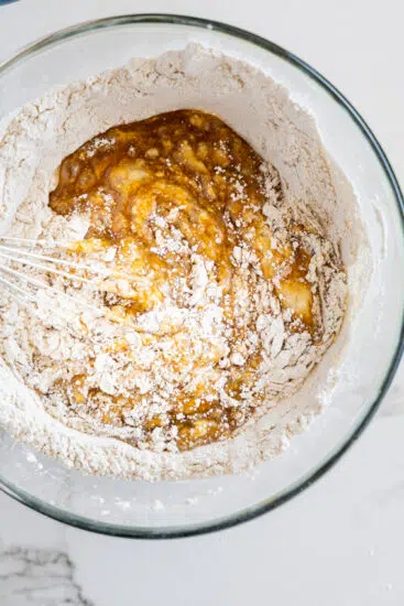 Dry ingredients mixed into wet ingredients for carrot cake batter.