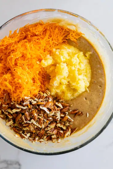 Grated carrots, pineapple and pecans stirred into batter.