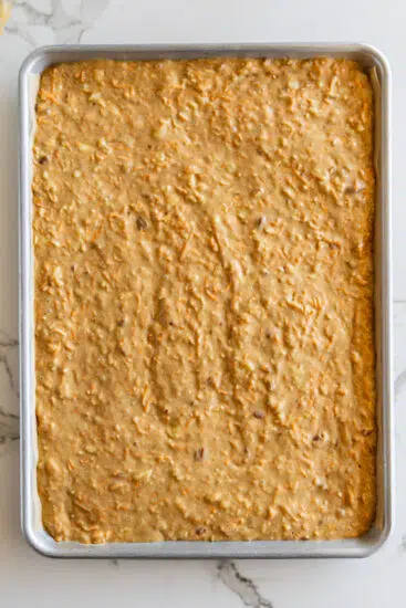 Carrot cake batter in lined sheet pan.