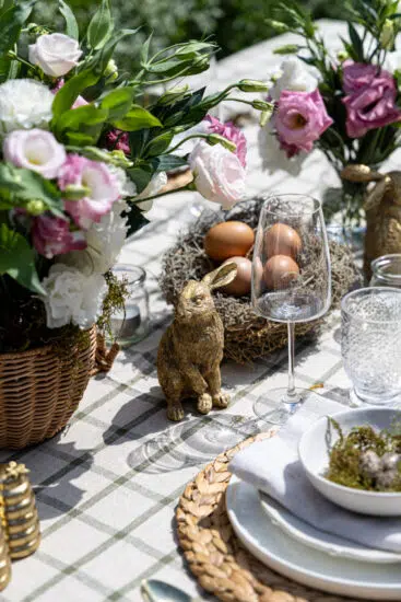 Easter Tablescape with bronze bunnies, green and pink flowers.