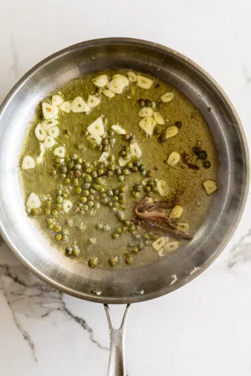 Capers, garlic and anchovies cooking in olive oil