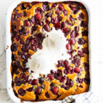 Cherry Cobbler with vanilla ice cream in a baking dish.