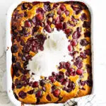Cherry Cobbler with vanilla ice cream in a baking dish.