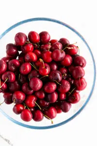 Fresh sweet cherries in a glass mixing bowl.