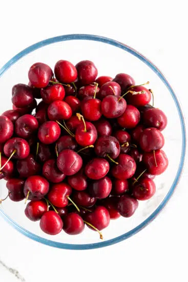 Fresh sweet cherries in a glass mixing bowl.
