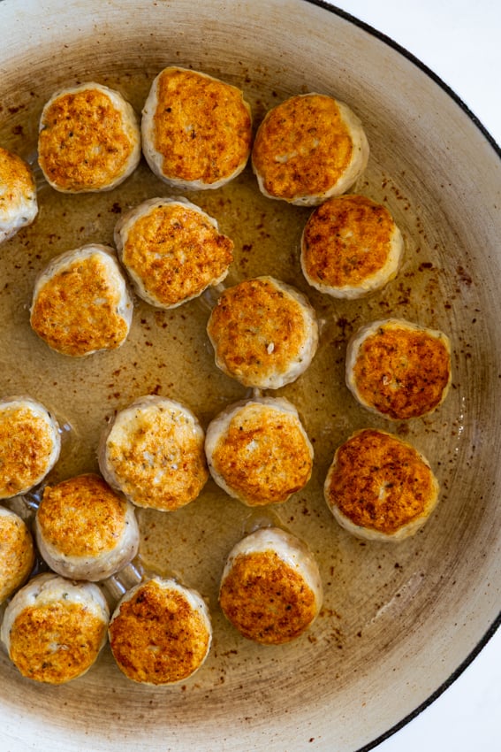 Chicken meatballs cooked in a large skillet.