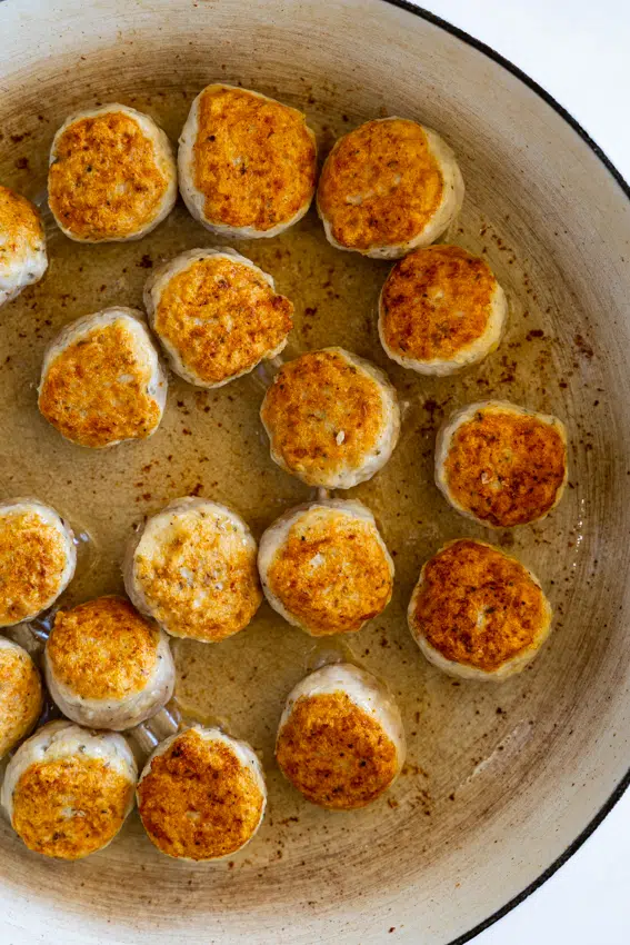 Chicken meatballs cooked in a large skillet.