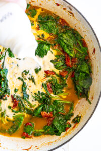 Cream poured into spinach sauce.