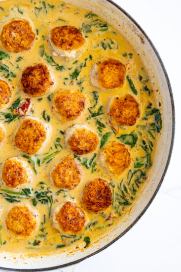 Chicken meatballs in creamy sauce with spinach and sun-dried tomatoes.