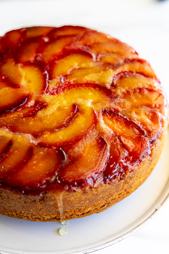 Plum Upside Down Cake on a white cake stand.
