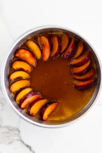 Sliced plums in cake pan.