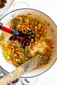 Red wine and aromatics sautéed in a white braiser.