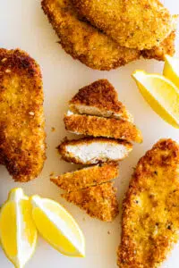 Breaded Chicken Cutlets with lemon wedges.