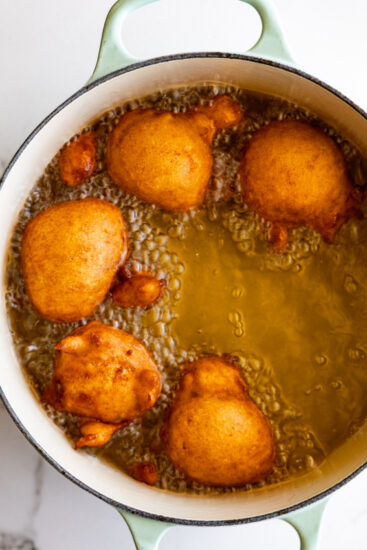 Applesauce fritters frying in canola oil.