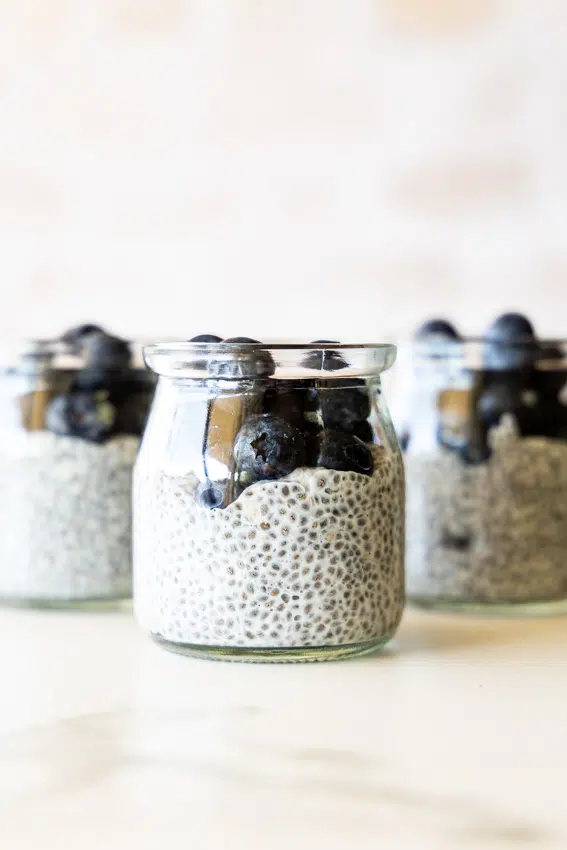 Easy Chia Pudding in glass jars with blueberries.
