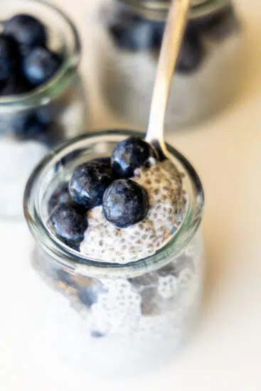 Chia pudding and blueberries in glass jars.