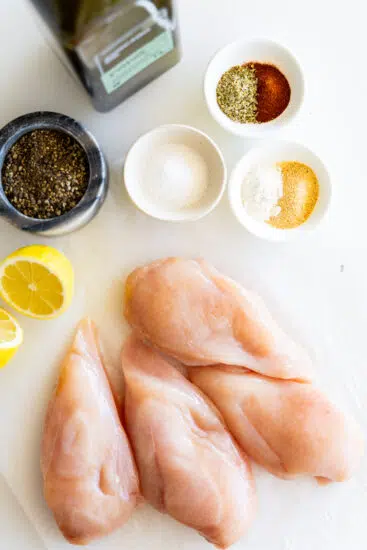 Ingredients for grilled chicken nuggets on a white surface.