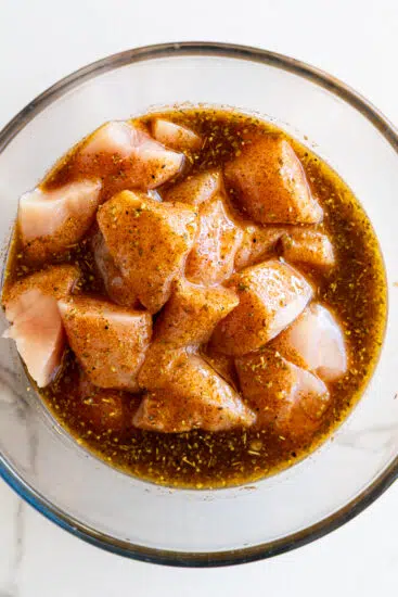 Marinated chicken in a glass bowl.
