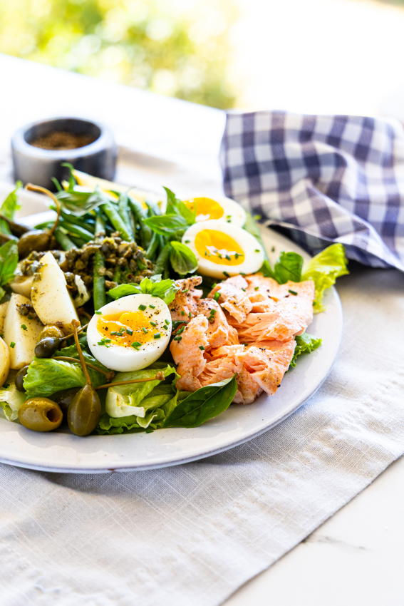 Salmon Niçoise Salad on a table with a napkin.