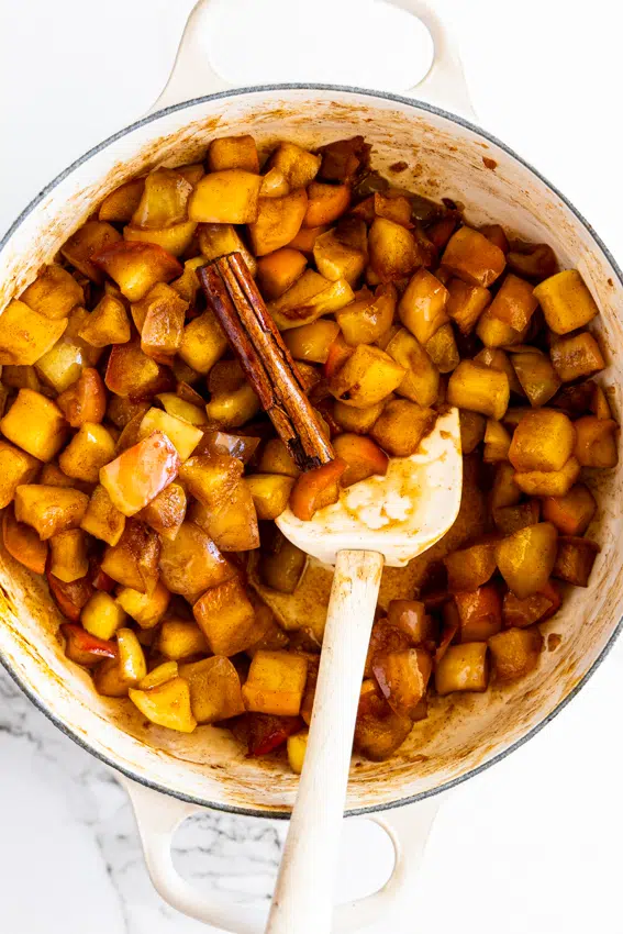 Stewed apples with cinnamon in a saucepan.