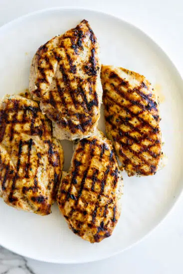 Grilled chicken breasts on a white plate.