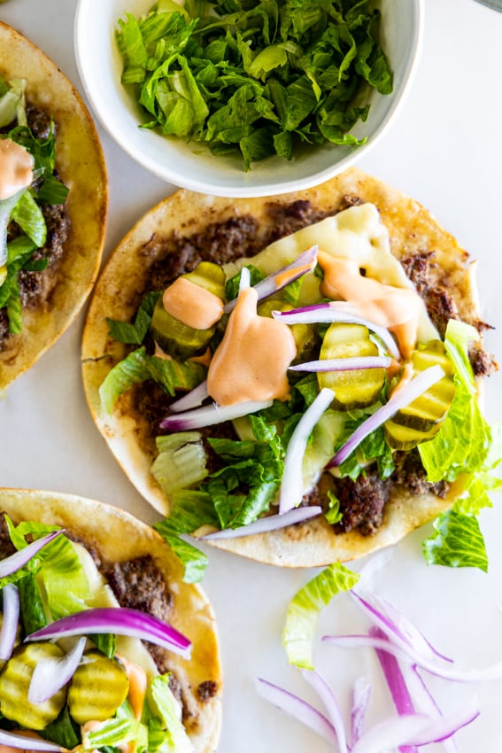 Smashed Burger Tacos with pickles, burger sauce and shredded lettuce.
