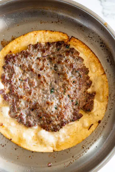 Smashed lamb wraps in pan.