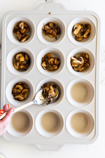 Sautéed mushrooms placed into silicone muffin pan.