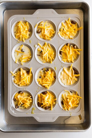 Uncooked egg bites in muffin tray in Bain Marie.
